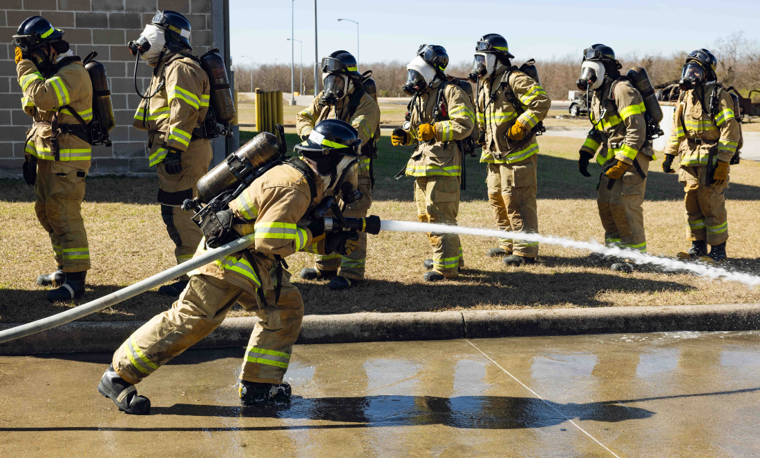 Fire academy students work on a drill using the fire hoses.